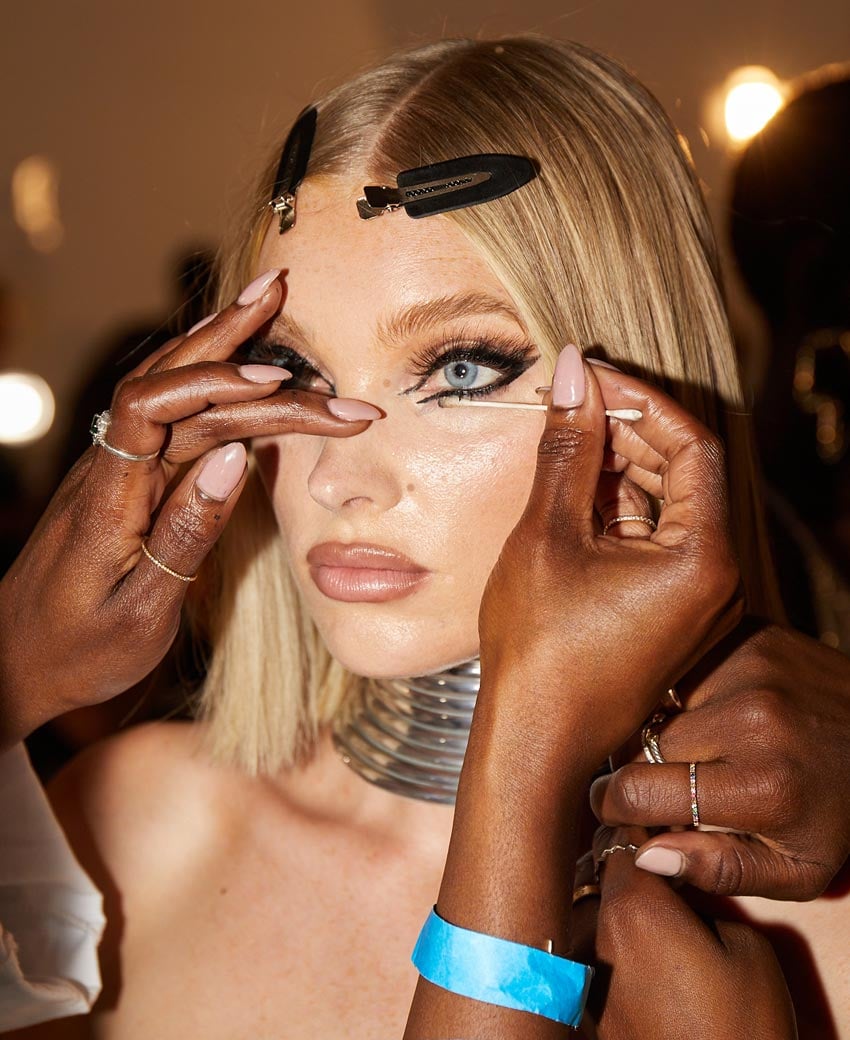 Lancome Makeup Artist Shieka Daley cleaning up the futuristic cat eye on a model with a cotton tip